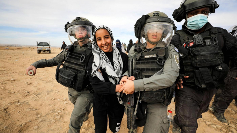 قوات الاحتلال تعتدي على امرأة فلسطينية خلال تظاهرة في قرية الأطرش في النقب (رويترز).