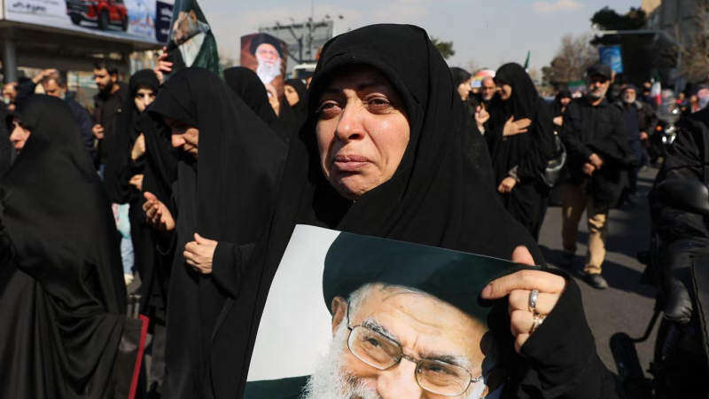 امرأة تحمل صورة المرشد الأعلى الإيراني الراحل آية الله علي خامنئي خلال تجمع في طهران يوم الجمعة (وكالة أنباء غرب آسيا)